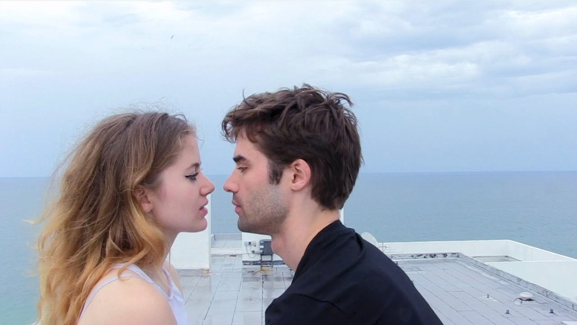 A young woman and a young man about to kiss