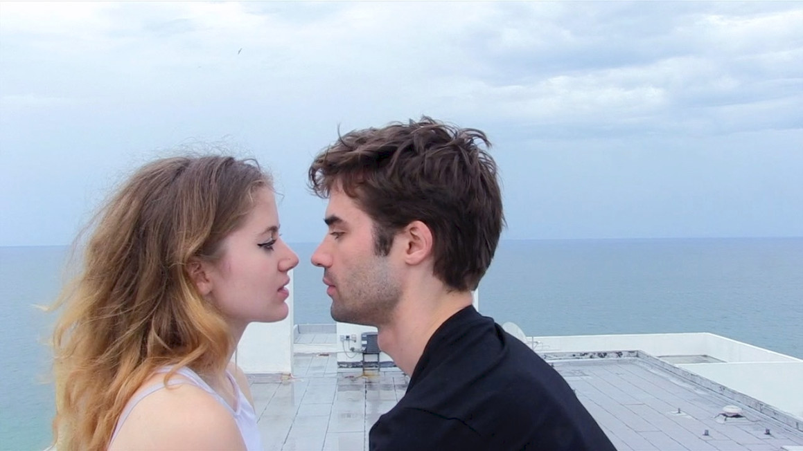 A young woman and a young man about to kiss