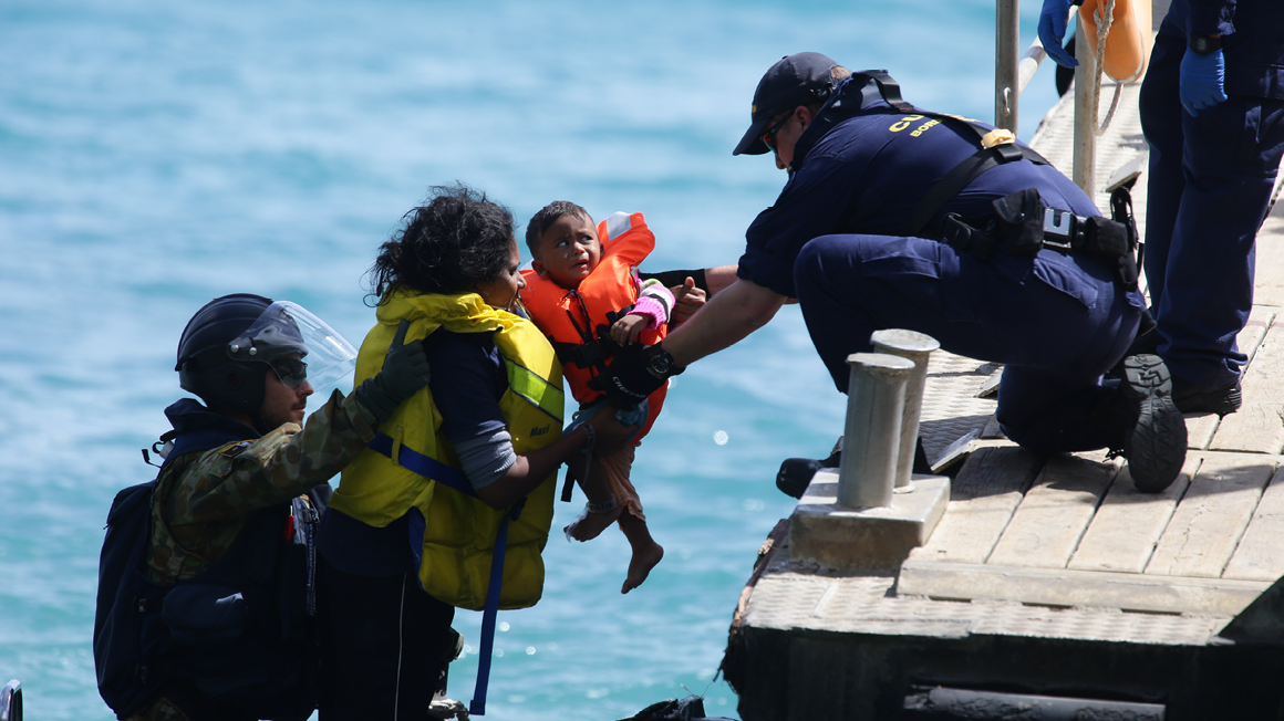 Asylum seekers at Flying Fish Cove Christmas Island are transferred to the jetty by crew from the HMAS Maryborough and Australian Customs and Border Protection Service after their boat crashed onto cliffs. 