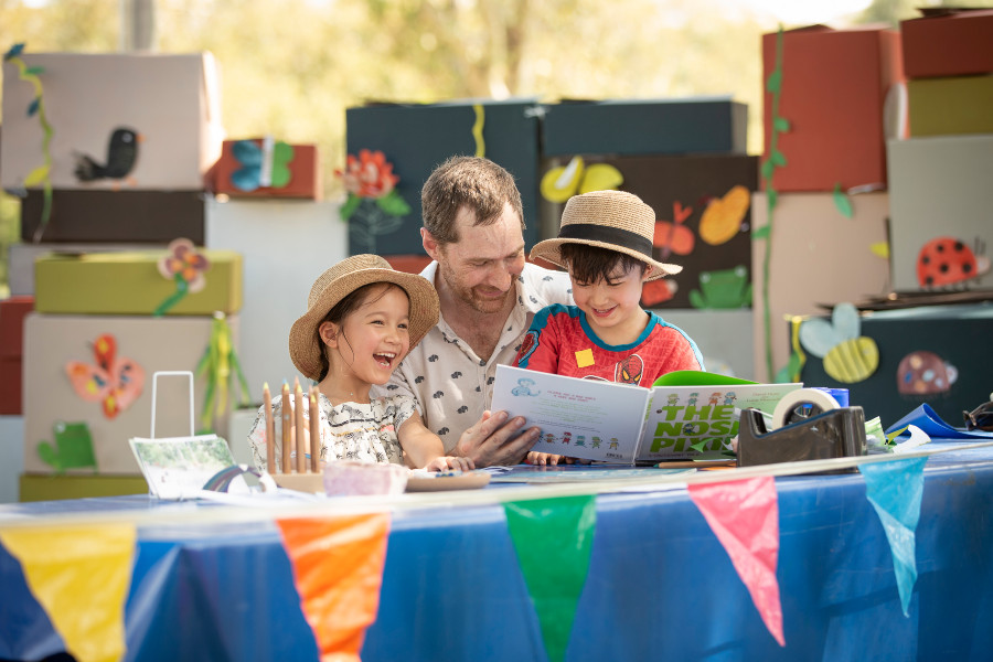 Little girl and boy reading with dad